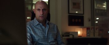 Movie still from “Miss Sloane” (2016), directed by John Madden – A bald man sitting in a chair in a room; Close Up shot, Over the shoulder angle