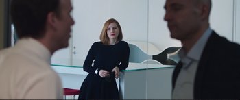 Movie still from “Miss Sloane” (2016), directed by John Madden – A woman standing in front of a mirror holding a camera; Medium shot, Over the shoulder angle