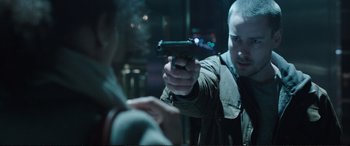 Movie still from “Miss Sloane” (2016), directed by John Madden – A man holding a gun in front of another man; Close Up shot, Over the shoulder angle