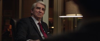 Movie still from “Miss Sloane” (2016), directed by John Madden – An older man wearing a suit and red tie; Close Up shot, Over the shoulder angle
