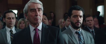 Movie still from “Miss Sloane” (2016), directed by John Madden – A man in a suit and tie next to another man in a suit and tie; Close Up shot, Over the shoulder angle