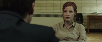 Movie still from “Miss Sloane” (2016), directed by John Madden – A woman sitting in front of a man in front of a brick wall; Close Up shot, Over the shoulder angle