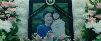 Movie still from “Night in Paradise” (2020), directed by Park Hoon-jung – A woman and a child are in a picture frame; Extreme Close Up shot, Low angle