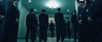 Movie still from “Night in Paradise” (2020), directed by Park Hoon-jung – A group of men standing in front of a wall; Wide shot, Low angle