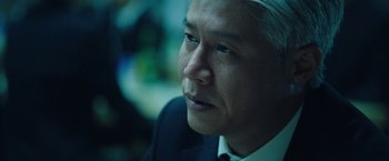 Movie still from “Night in Paradise” (2020), directed by Park Hoon-jung – A person wearing a suit and tie; Close Up shot, Over the shoulder angle