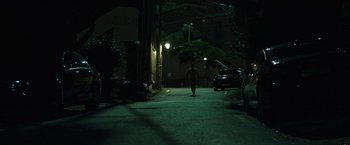 Movie still from “Night in Paradise” (2020), directed by Park Hoon-jung – A person walking down a street at night; Extreme Wide shot, Low angle