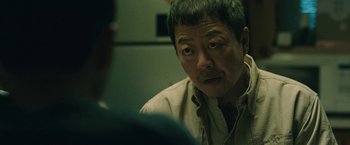Movie still from “Night in Paradise” (2020), directed by Park Hoon-jung – An asian man is looking at another asian man; Close Up shot, Over the shoulder angle