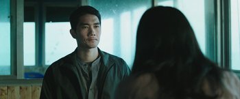Movie still from “Night in Paradise” (2020), directed by Park Hoon-jung – A man and a woman are looking at one another; Close Up shot, Over the shoulder angle