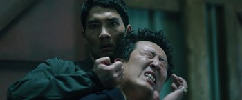 Movie still from “Night in Paradise” (2020), directed by Park Hoon-jung – A man is holding a knife over another man's face; Close Up shot, Over the shoulder angle
