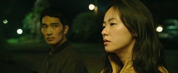 Movie still from “Night in Paradise” (2020), directed by Park Hoon-jung – A man and a woman standing next to each other; Close Up shot, Over the shoulder angle
