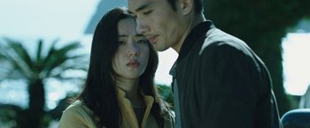 Movie still from “Night in Paradise” (2020), directed by Park Hoon-jung – A man and a woman standing next to each other; Close Up shot, Low angle