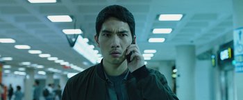 Movie still from “Night in Paradise” (2020), directed by Park Hoon-jung – A young man is talking on a cell phone; Close Up shot, Low angle