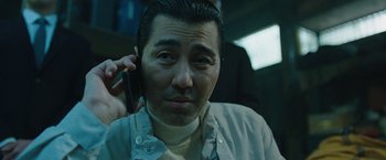Movie still from “Night in Paradise” (2020), directed by Park Hoon-jung – A person talking on a cell phone; Close Up shot, Low angle