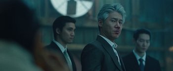Movie still from “Night in Paradise” (2020), directed by Park Hoon-jung – Two men in suits standing next to each other; Close Up shot, Low angle