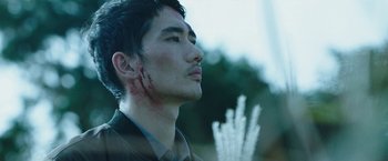 Movie still from “Night in Paradise” (2020), directed by Park Hoon-jung – A young man with blood on his face and neck; Close Up shot, Low angle