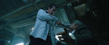 Movie still from “Night in Paradise” (2020), directed by Park Hoon-jung – A man in a white shirt and a man in a blue jacket; Medium shot, Low angle
