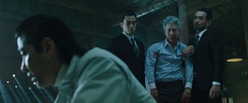 Movie still from “Night in Paradise” (2020), directed by Park Hoon-jung – Two men in suits and ties standing in a room; Medium shot, Low angle
