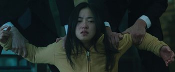 Movie still from “Night in Paradise” (2020), directed by Park Hoon-jung – A woman with her hands on her shoulders; Close Up shot, High angle