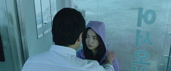 Movie still from “Night in Paradise” (2020), directed by Park Hoon-jung – A young man and a young woman looking at one another; Close Up shot, Over the shoulder angle