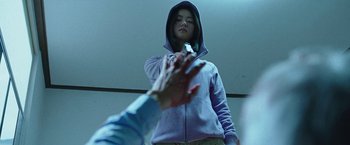 Movie still from “Night in Paradise” (2020), directed by Park Hoon-jung – Two people shaking hands while one is wearing a hooded sweatshirt; Medium shot, Low angle