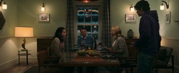 Movie still from “No One Gets Out Alive” (2021), directed by Santiago Menghini – A group of people sitting at a table with a glass of wine; Medium shot, High angle