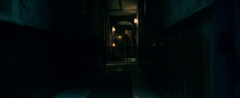 Movie still from “No One Gets Out Alive” (2021), directed by Santiago Menghini – A person walking down a dark hallway at night; Wide shot, Low angle