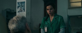 Movie still from “No One Gets Out Alive” (2021), directed by Santiago Menghini – A woman in a green shirt is looking at a man; Close Up shot, Over the shoulder angle
