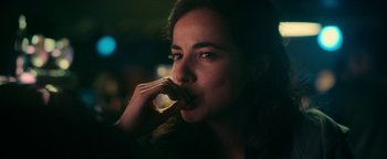 Movie still from “No One Gets Out Alive” (2021), directed by Santiago Menghini – A person eating a piece of food; Close Up shot, Over the shoulder angle