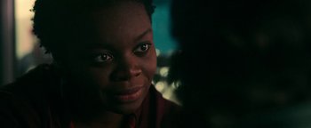Movie still from “No One Gets Out Alive” (2021), directed by Santiago Menghini – A person smiling for the camera; Close Up shot, Over the shoulder angle