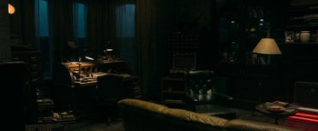 Movie still from “No One Gets Out Alive” (2021), directed by Santiago Menghini – A living room filled with furniture next to a desk; Wide shot, High angle