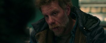 Movie still from “No One Gets Out Alive” (2021), directed by Santiago Menghini – A person with a beard; Close Up shot, Over the shoulder angle