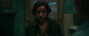 Movie still from “No One Gets Out Alive” (2021), directed by Santiago Menghini – A young woman is standing in front of a window; Close Up shot, Over the shoulder angle