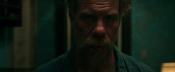 Movie still from “No One Gets Out Alive” (2021), directed by Santiago Menghini – A person with a beard; Close Up shot, Low angle