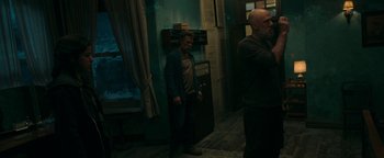 Movie still from “No One Gets Out Alive” (2021), directed by Santiago Menghini – A man standing in a room next to another man; Medium shot, Over the shoulder angle