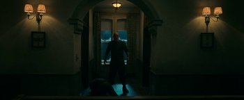Movie still from “No One Gets Out Alive” (2021), directed by Santiago Menghini – A man standing in front of an open window; Wide shot, Low angle