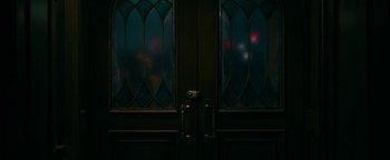 Movie still from “No One Gets Out Alive” (2021), directed by Santiago Menghini – A double door with a view of a window; Extreme Close Up shot, Low angle