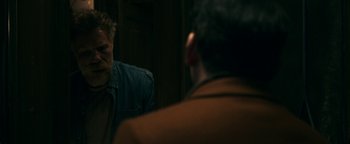 Movie still from “No One Gets Out Alive” (2021), directed by Santiago Menghini – Two men are looking at each other in a mirror; Medium shot, Over the shoulder angle