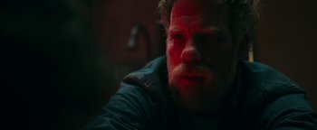 Movie still from “No One Gets Out Alive” (2021), directed by Santiago Menghini – A person with a beard; Close Up shot, Over the shoulder angle