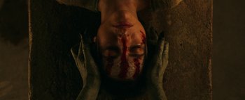 Movie still from “No One Gets Out Alive” (2021), directed by Santiago Menghini – A man with blood on his face and hands; Extreme Close Up shot, Overhead angle