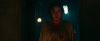 Movie still from “No One Gets Out Alive” (2021), directed by Santiago Menghini – A woman with blood all over her face and neck; Close Up shot, Over the shoulder angle