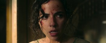 Movie still from “No One Gets Out Alive” (2021), directed by Santiago Menghini – A person with blood all over her face; Close Up shot, High angle