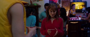 Movie still from “No Strings Attached” (2011), directed by Ivan Reitman – A woman holding a cell phone in her hands; Medium shot, Over the shoulder angle