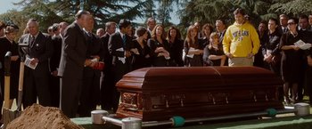 Movie still from “No Strings Attached” (2011), directed by Ivan Reitman – A group of people standing around a casket; Wide shot, Over the shoulder angle