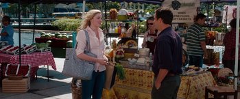 Movie still from “No Strings Attached” (2011), directed by Ivan Reitman – A woman standing in front of a table of food; Medium shot, Over the shoulder angle