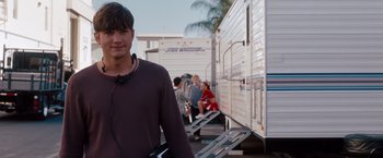 Movie still from “No Strings Attached” (2011), directed by Ivan Reitman – A man standing in front of a group of trailers; Medium shot, Over the shoulder angle