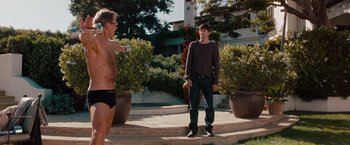 Movie still from “No Strings Attached” (2011), directed by Ivan Reitman – A man and a boy standing next to each other on steps; Medium shot, Over the shoulder angle