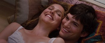Movie still from “No Strings Attached” (2011), directed by Ivan Reitman – A man and a woman laying on the ground smiling for the camera; Close Up shot, Overhead angle
