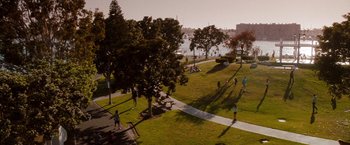 Movie still from “No Strings Attached” (2011), directed by Ivan Reitman – People are walking on the grass near the water; Extreme Wide shot, High angle