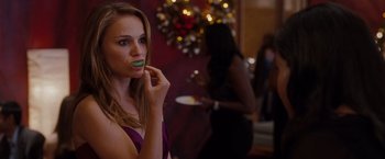 Movie still from “No Strings Attached” (2011), directed by Ivan Reitman – A beautiful young lady holding a plate of food in front of her face; Close Up shot, Over the shoulder angle