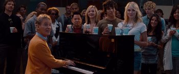 Movie still from “No Strings Attached” (2011), directed by Ivan Reitman – A group of people standing next to each other holding drinks; Medium shot, Over the shoulder angle